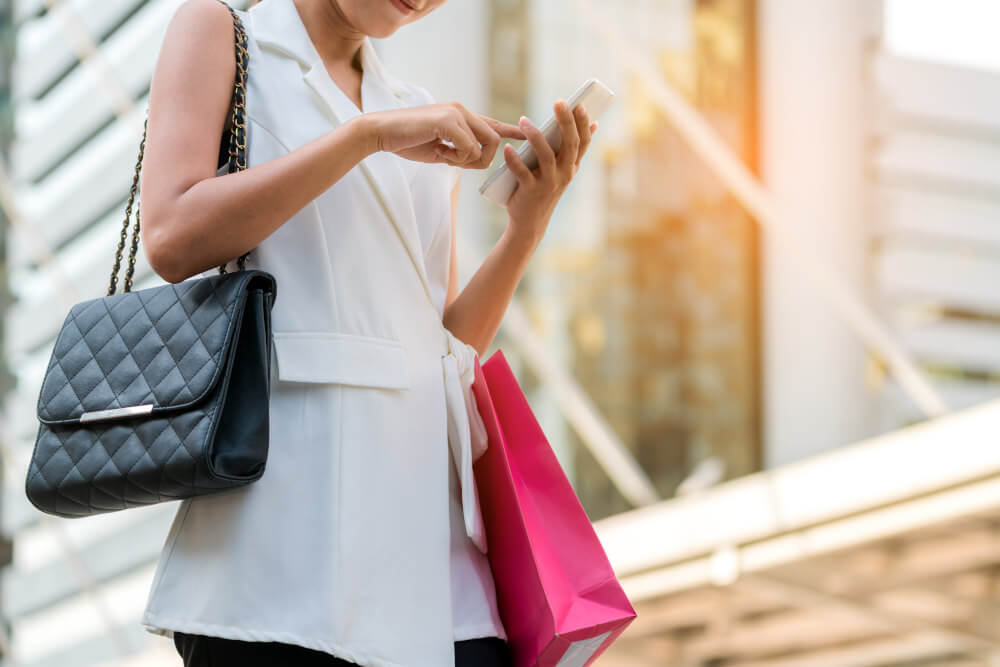 woman-with-shopping-bags-handbag-and-smartphone